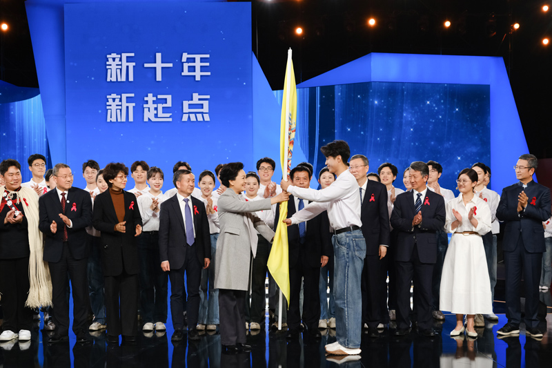 彭丽媛教授为大学生防艾志愿者代表授旗1.jpg